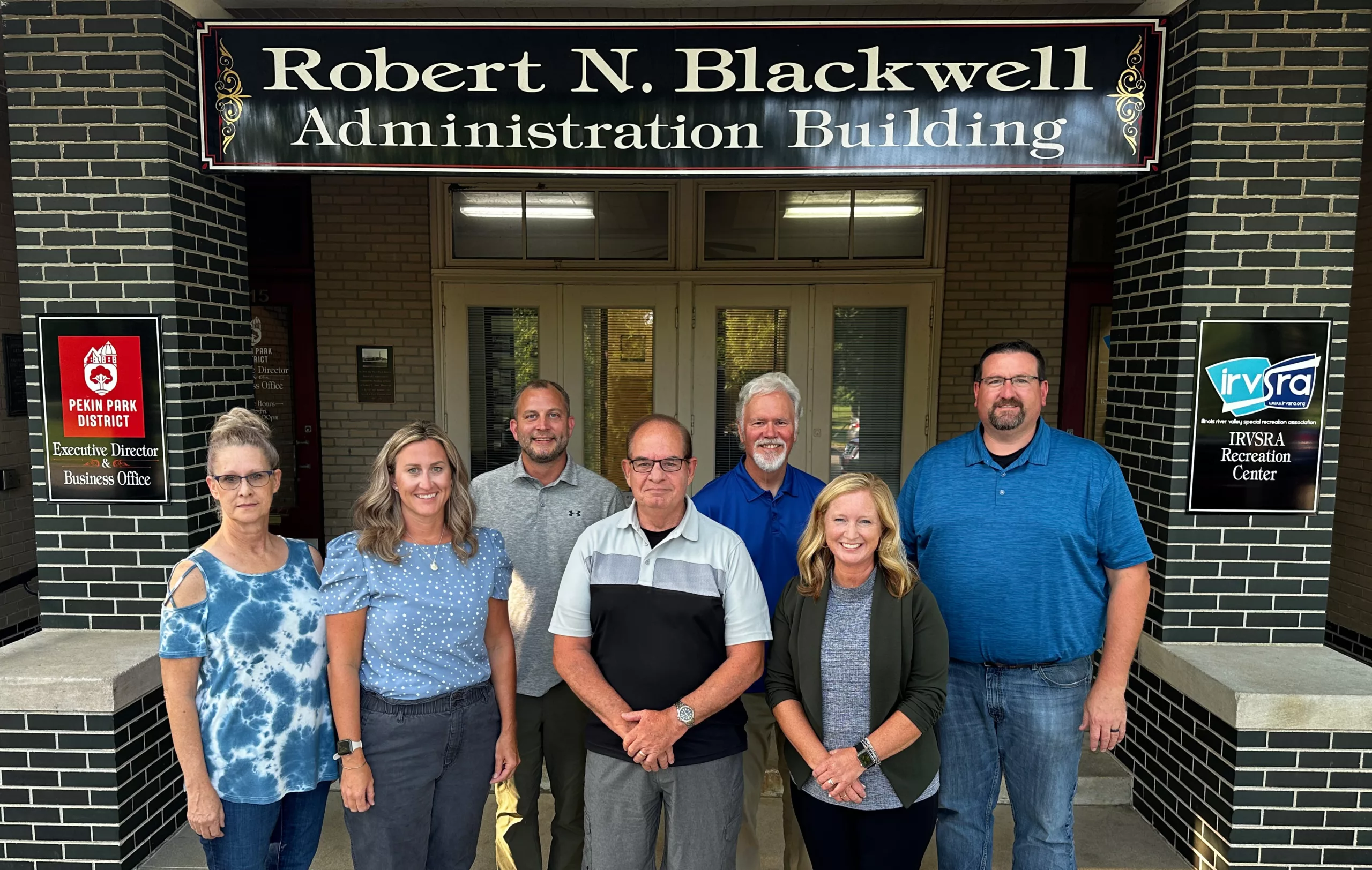 The Park Board standing in front of the Robert N. Blackwell Administration Building