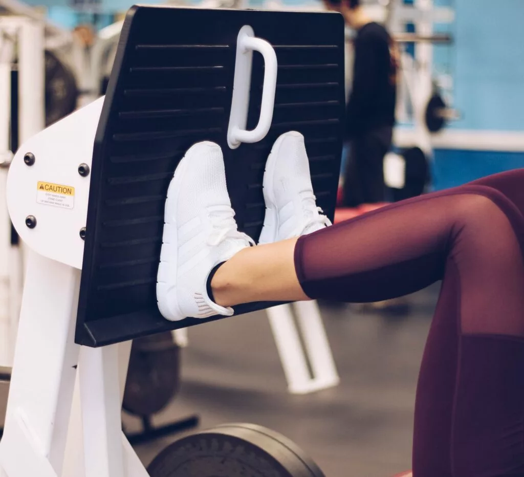 woman using a leg press machine at a gym in Pekin