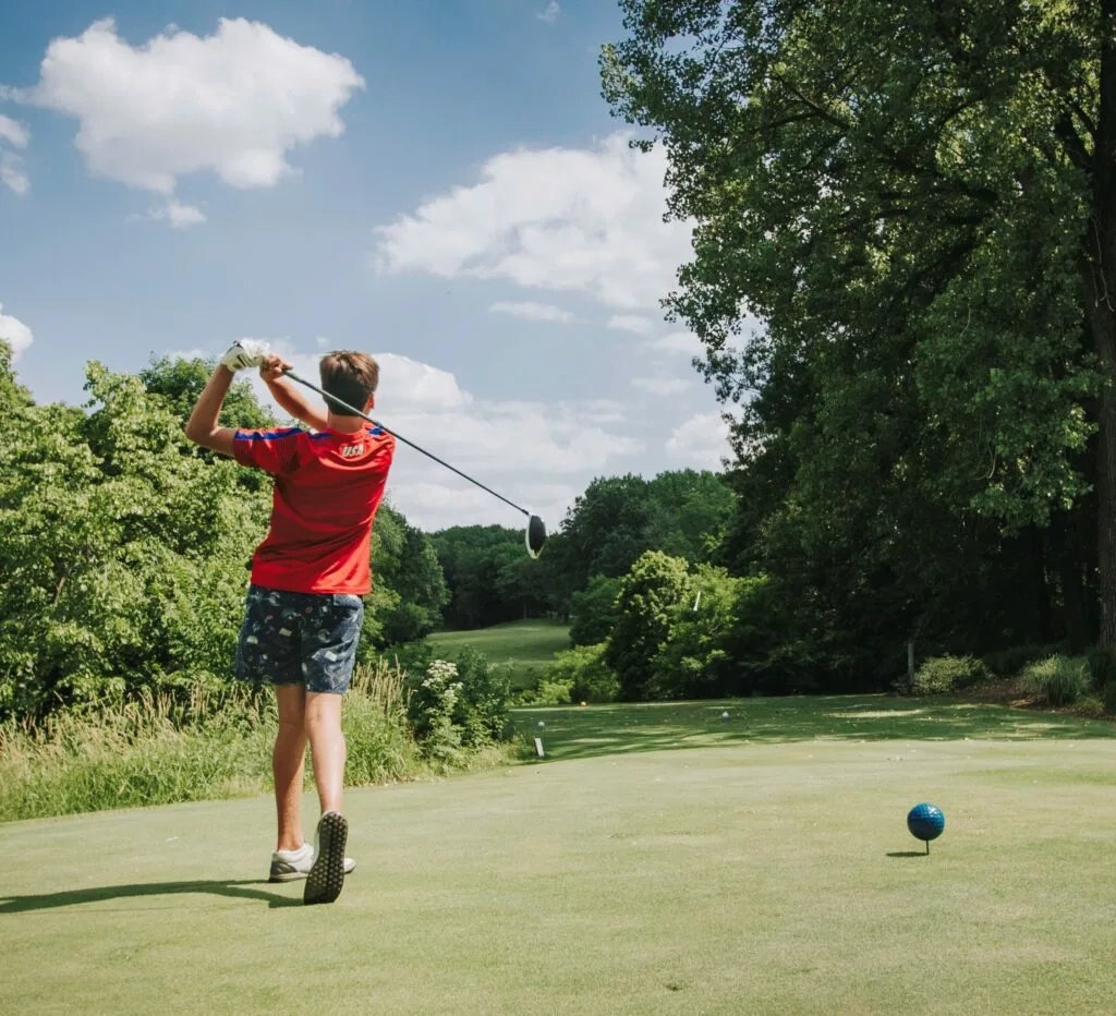 Boy playing golf in a lush green golf course in Pekin