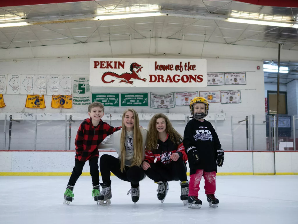 siblings posing for a picture on an ice rink