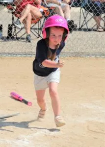 little girl running to first base